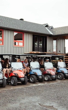 Lineup of people in golf carts outside of a luxury cottage